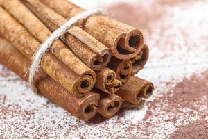 Cinnamon sticks and cocoa powder accessories for a cozy winter evening near the fireplace with a glass of wine photo