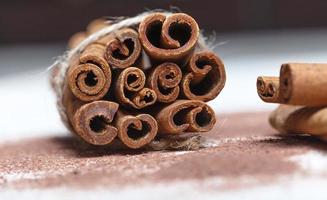 Cinnamon sticks and cocoa powder accessories for a cozy winter evening near the fireplace with a glass of wine photo