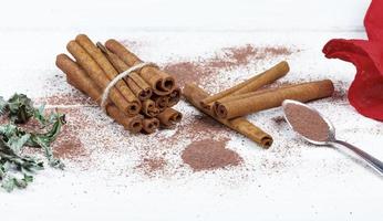 Cinnamon sticks and cocoa powder accessories for a cozy winter evening near the fireplace with a glass of wine photo