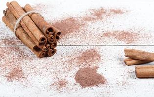 Cinnamon sticks and cocoa powder accessories for a cozy winter evening near the fireplace with a glass of wine photo