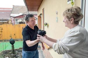 Women greeting men at doorway with electronic gadget purchase with online order photo