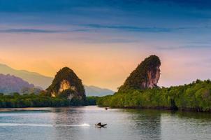 Khao kha nab nam at Krabi Thailand. The famous tourist attraction in southern of thailand. Twin mountains have rivers through the middle of the evening atmosphere with golden light. photo