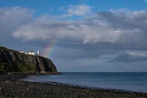 Arco iris sobre el faro de Whitehead, Irlanda del Norte, Reino Unido foto