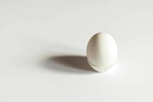 huevo blanco sobre un fondo blanco aislado con sombra. ingrediente comida sana pascua. foto