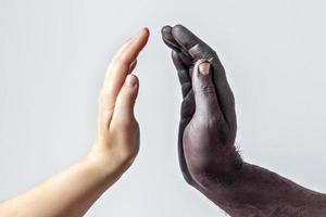 manos negras masculinas y blancas femeninas, palmas abiertas entre sí. un símbolo de la lucha por los derechos de los negros en Estados Unidos. el concepto de igualdad y la lucha contra el racismo foto