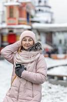 Portrait of a young woman in warm winter clothes outdoors while traveling. Winter time, snow photo