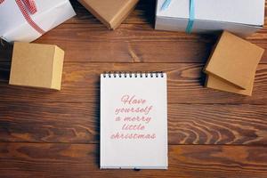 Top view of spiral notebook and gift boxes on wood table background. photo