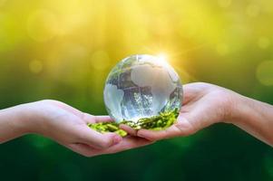 Concept Save the world save environment The world is in the grass of the green bokeh background photo
