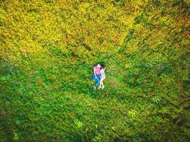 Couple kissing in nature sunny green field outdoors together from aerial perspective