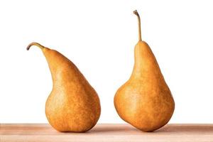 Two Williams or Bartlett pears on wooden table with isolated white background.