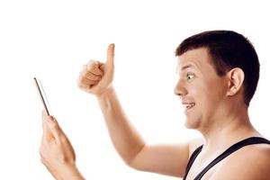 Happy man with thumb up reading some good news from his tablet. Human emotion, reaction, expression. Isolated on white background. photo