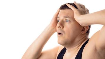 Desperate stressed worried young man with hands on head. Isolated on white background. photo