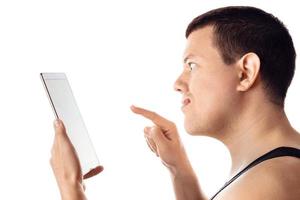 Angry frustrated man using a tablet. Human emotion, reaction, expression. Isolated on white background. photo