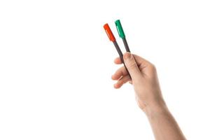 Male hand holds a two red and green markers or a felt pen. Isolated on white background. photo