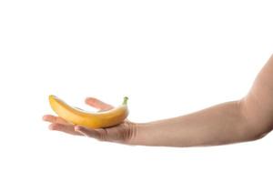 Male hand holding banana. Isolated on white background. photo