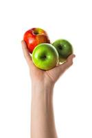Man holding bunch of red and green apples in his hand. Isolated on white background. photo