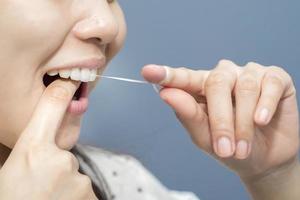 las mujeres sonrientes usan hilo dental dientes blancos sanos foto