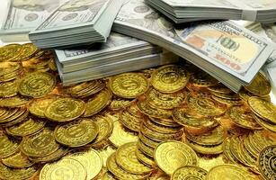 Pila de monedas de oro y billetes de dinero 100 usd foto
