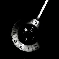 A vintage clock with a bright ray of light in black and white photo