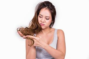 Asian woman worried about hair loss on white background. photo