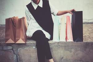 Mano de mujer sosteniendo bolsas de compras después de ir de compras en el centro comercial y caminar al estacionamiento foto