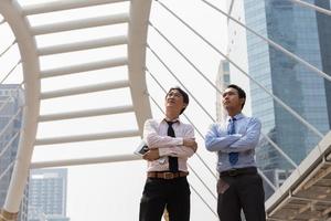 dos hombres de negocios asiáticos de pie en el distrito de negocios. foto