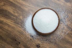 White sugar on wooden floor photo