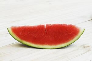 Fruta de sandía en rodajas sobre fondos de mesa de madera foto