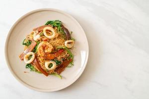 fideos de arroz salteados y mimosa de agua con una mezcla de mariscos foto