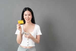Asian woman with happy face and presenting credit card in hand showing trust and confidence for making payment photo