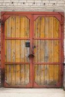 Old wooden plank door with metal frame and handles photo