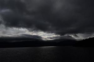 nubes grises sobre el cuerpo de agua durante el día foto