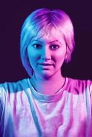 Portrait of young female woman with a white t-shirt and neon lights.