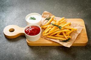 papas fritas con crema agria y salsa de tomate foto