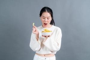 Young Asian woman eat potato chips photo