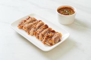 Grilled pork neck or charcoal-boiled pork neck with Thai spicy dipping sauce photo