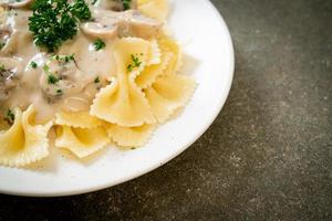 Farfalle pasta with mushroom white cream sauce - Italian food style photo