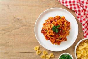 Pasta farfalle en salsa de tomate con perejil - estilo de comida italiana foto