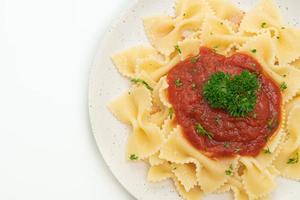 Pasta farfalle en salsa de tomate con perejil - estilo de comida italiana foto