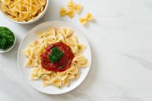 Pasta farfalle en salsa de tomate con perejil - estilo de comida italiana foto