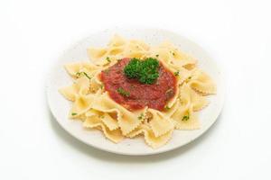 Pasta farfalle en salsa de tomate con perejil - estilo de comida italiana foto