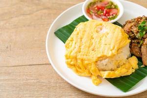 Huevo sobre arroz con cerdo a la parrilla y salsa picante - estilo de comida asiática foto