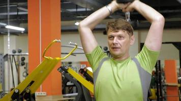 Hombre haciendo press de banca con pesas en fitness studio video
