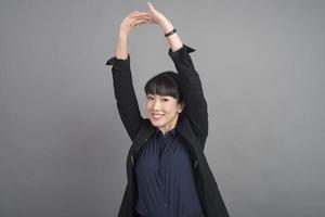 Smiling business woman in blazer on grey background photo