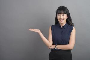 Smiling business woman in blazer on grey background photo