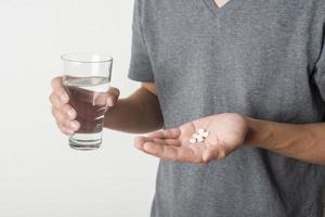 Man taking pill on white background photo