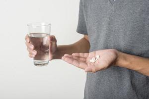 Man taking pill on white background photo