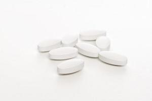 White pills on white background photo