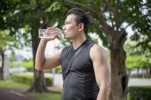 Sport man Drinking water at outdoor city photo