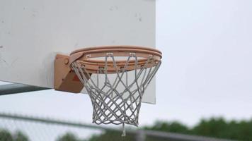 basket che entra nel canestro da basket all'aperto. video